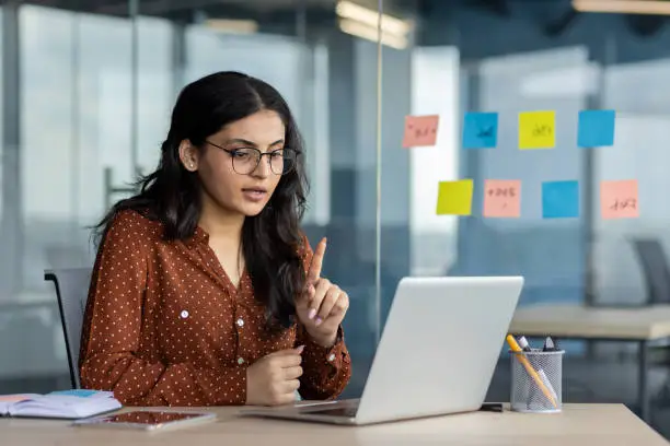 A woman entrepreneur focused on her laptop, managing her startup. 
